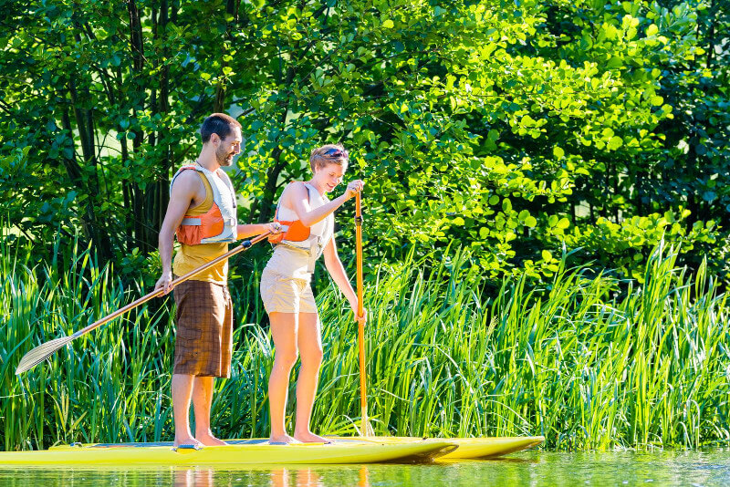 Mann und Frau paddeln im Wasser